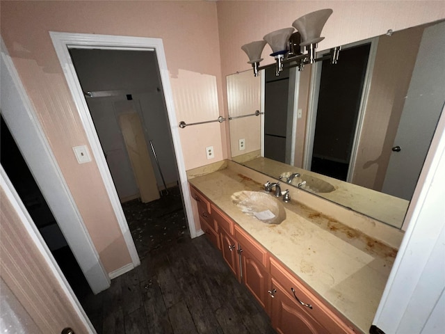 bathroom featuring vanity, baseboards, and wood finished floors