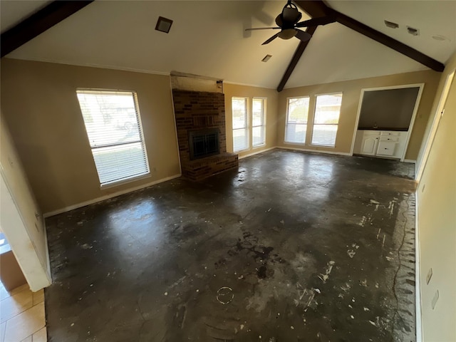 unfurnished living room with a wealth of natural light, beam ceiling, concrete flooring, and a fireplace