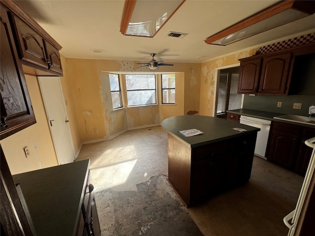 kitchen featuring visible vents, a sink, dark countertops, white dishwasher, and crown molding