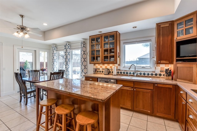 kitchen with a sink, tasteful backsplash, and brown cabinetry