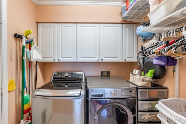 laundry room with cabinet space, crown molding, and separate washer and dryer