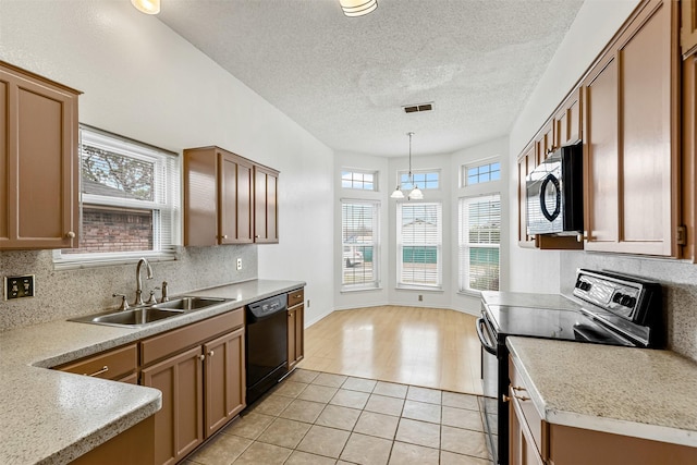 kitchen with light countertops, visible vents, decorative backsplash, a sink, and black appliances