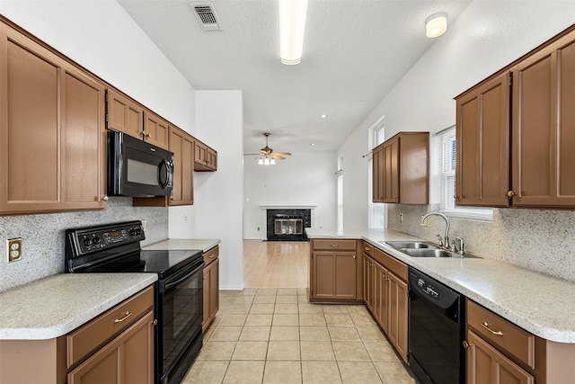 kitchen featuring light tile patterned floors, visible vents, a ceiling fan, black appliances, and a sink