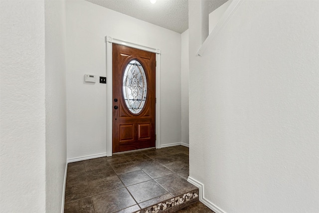 entrance foyer with a textured ceiling and baseboards