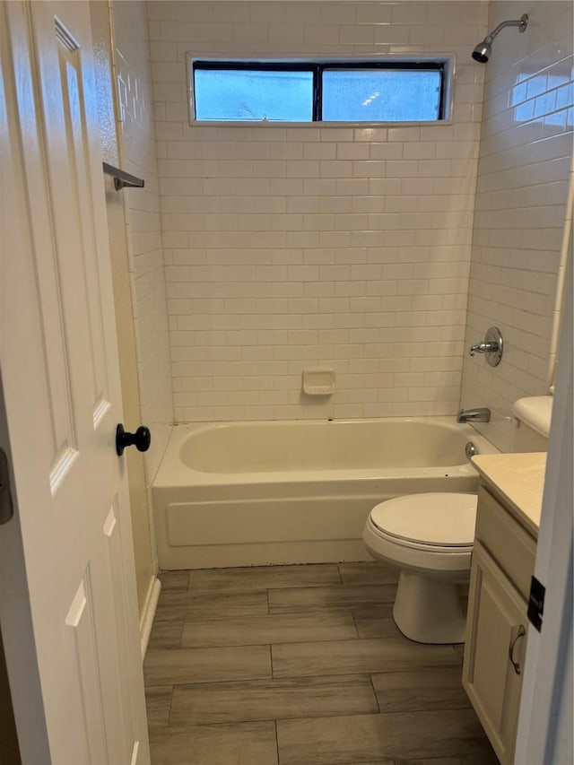 full bath featuring toilet, wood finish floors, vanity, and bathing tub / shower combination