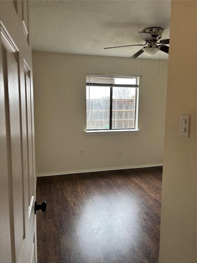 spare room with a textured ceiling, ceiling fan, wood finished floors, and baseboards