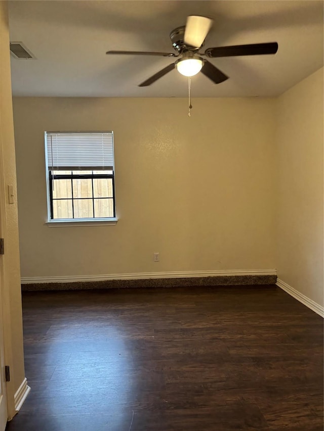 unfurnished room featuring ceiling fan, baseboards, visible vents, and dark wood finished floors