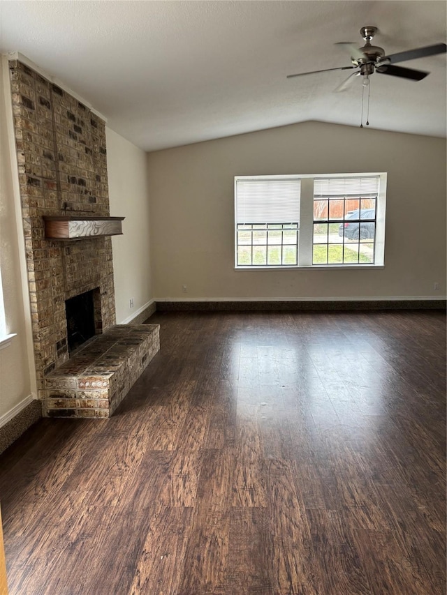 unfurnished living room featuring baseboards, ceiling fan, dark wood-style flooring, vaulted ceiling, and a fireplace