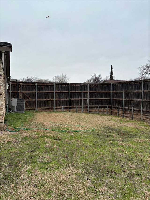 view of yard featuring central AC unit and fence