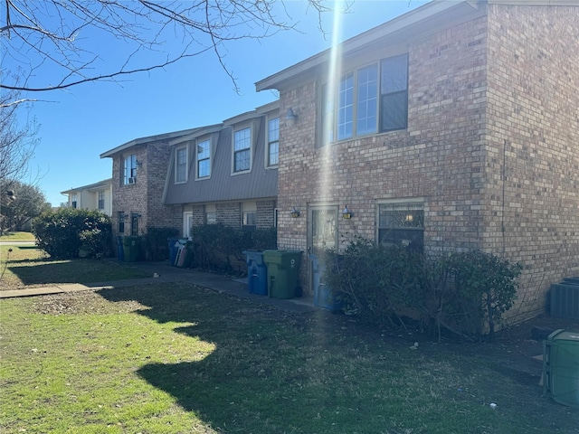 exterior space with a yard and brick siding