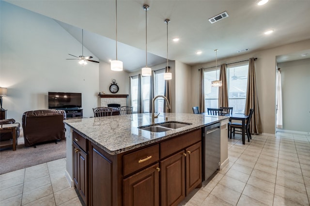 kitchen featuring visible vents, a sink, light tile patterned flooring, a fireplace, and dishwasher