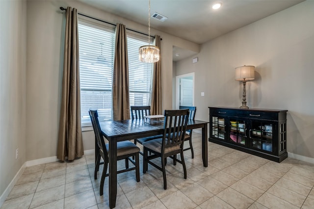 dining space featuring light tile patterned floors, visible vents, baseboards, and a notable chandelier