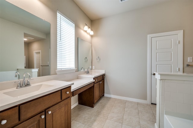 full bath with a sink, baseboards, double vanity, and tile patterned flooring