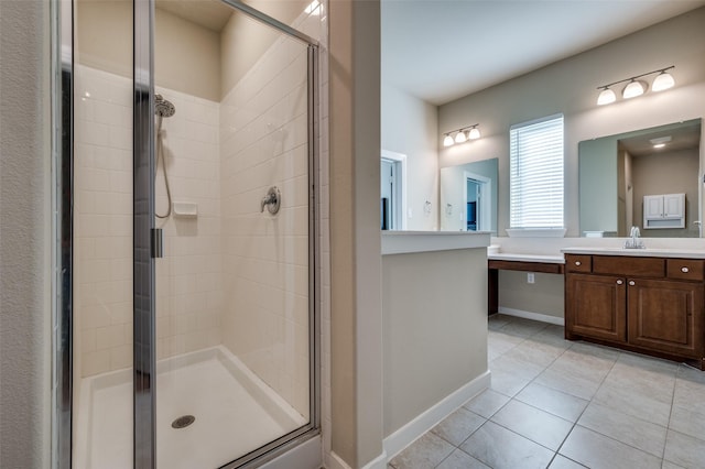 full bath with tile patterned floors, baseboards, vanity, and a shower stall