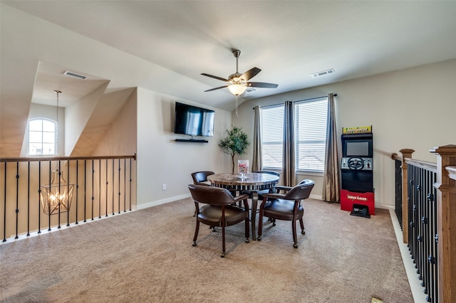 dining space with visible vents, light carpet, baseboards, and ceiling fan with notable chandelier