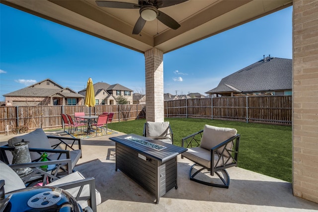 view of patio with a fenced backyard, outdoor dining space, a fire pit, and a ceiling fan