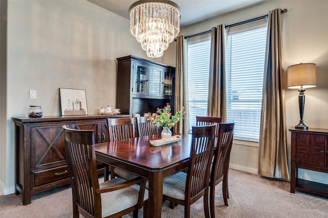 dining space with baseboards, light colored carpet, and a chandelier