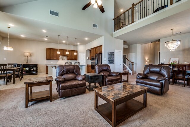 living room with light carpet, visible vents, recessed lighting, and ceiling fan with notable chandelier