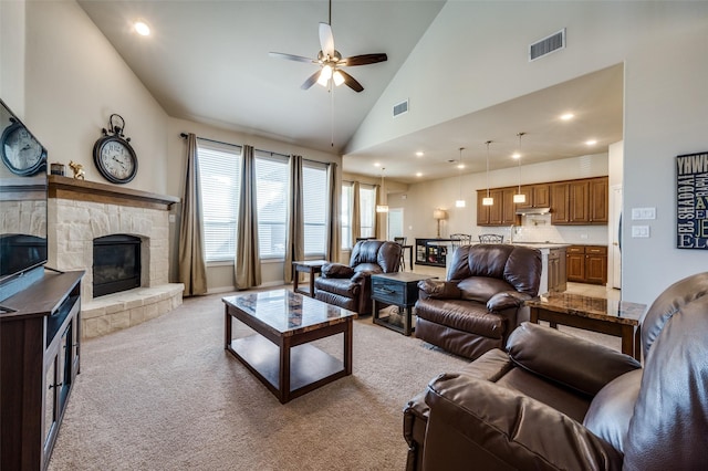 living room with high vaulted ceiling, a fireplace, visible vents, and light carpet