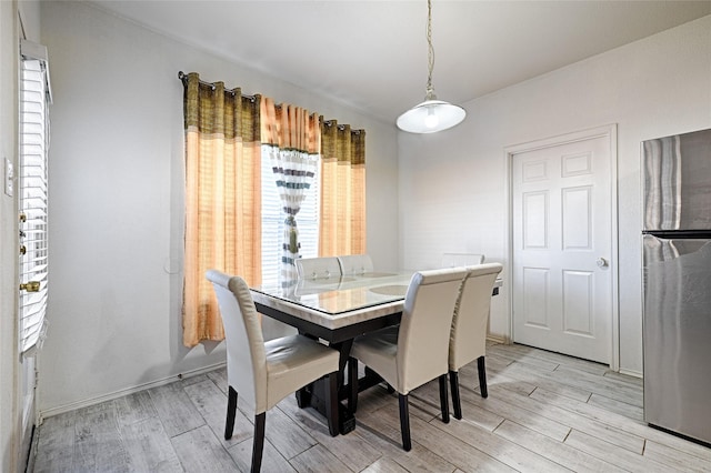 dining room with baseboards and light wood-style floors