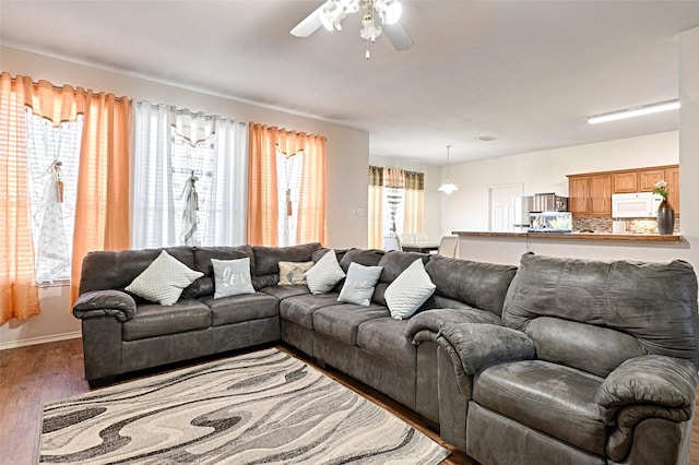 living room featuring dark wood-style floors, baseboards, and a ceiling fan