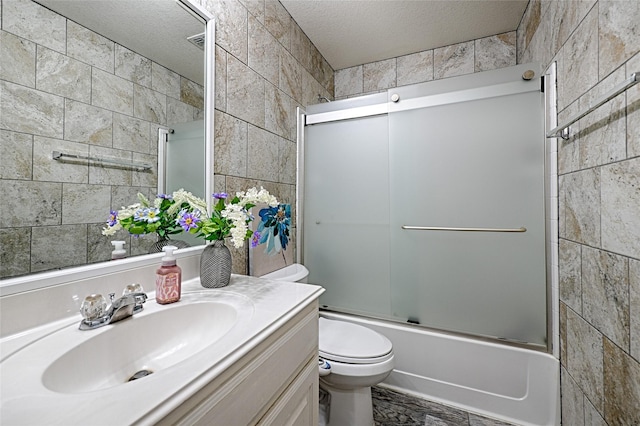 bathroom featuring toilet, enclosed tub / shower combo, tile walls, and a textured ceiling