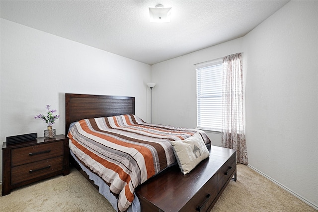 bedroom featuring a textured ceiling and light colored carpet