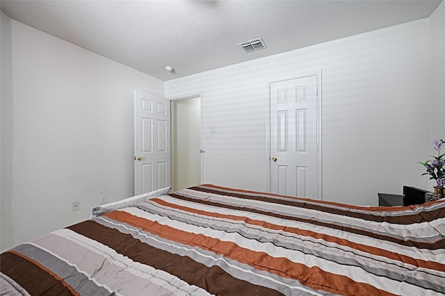 bedroom featuring visible vents and a textured ceiling