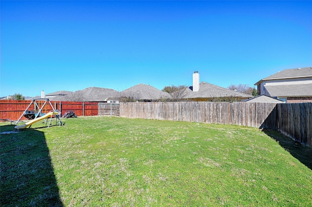 view of yard featuring a fenced backyard and a playground