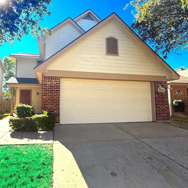 view of front of home with driveway, an attached garage, and brick siding