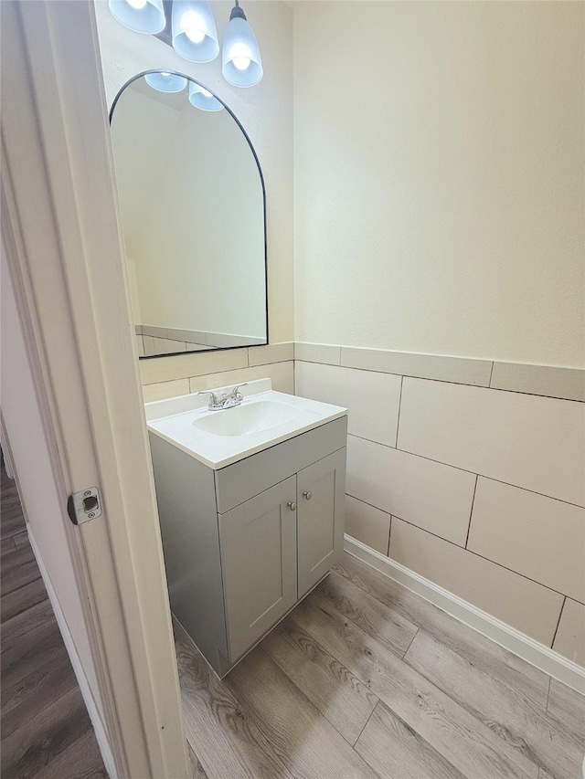 bathroom featuring wainscoting, wood finished floors, and vanity