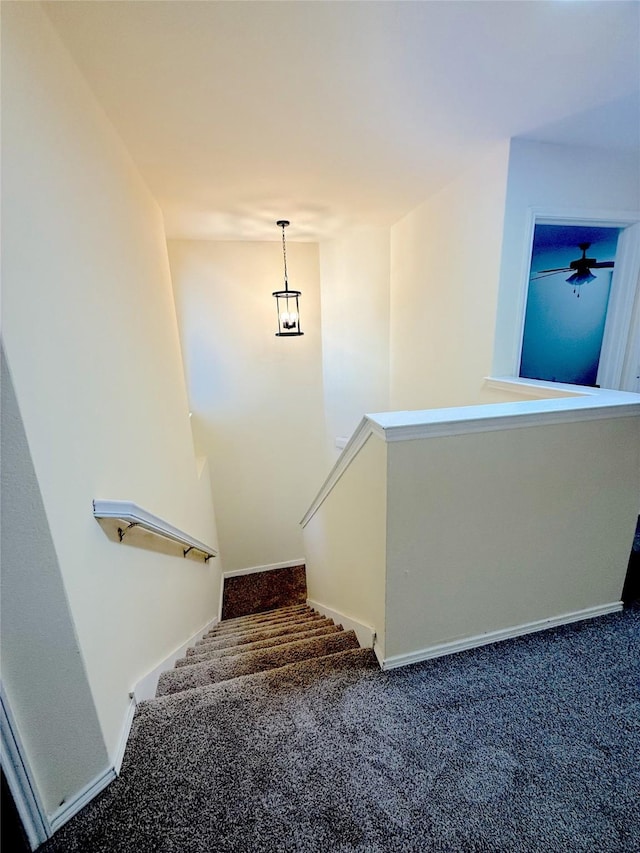 staircase featuring carpet floors and baseboards