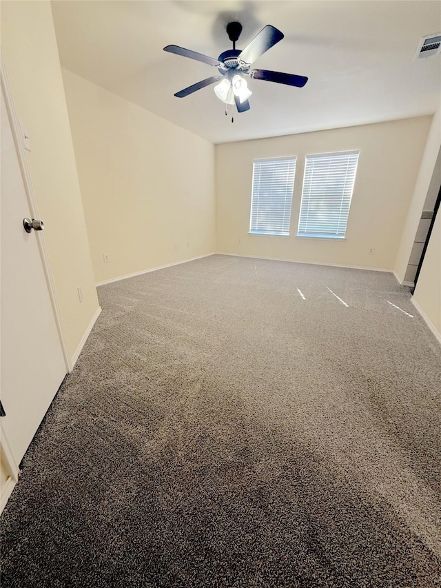 carpeted empty room with visible vents, ceiling fan, and baseboards