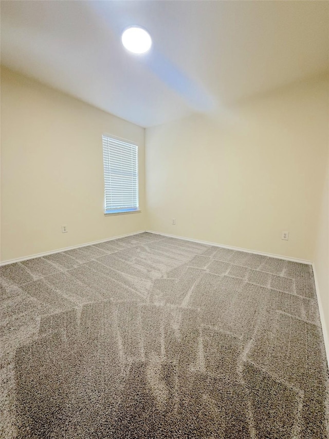 unfurnished room featuring carpet floors and baseboards