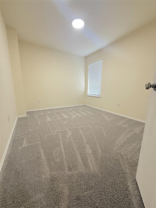 carpeted empty room with baseboards