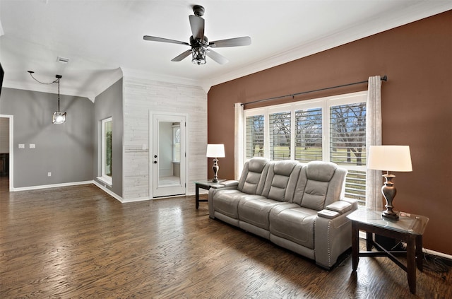 living room featuring crown molding, baseboards, and wood finished floors