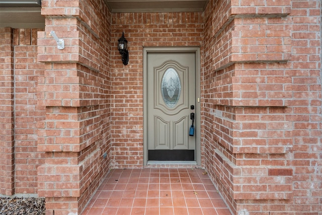 view of exterior entry featuring brick siding