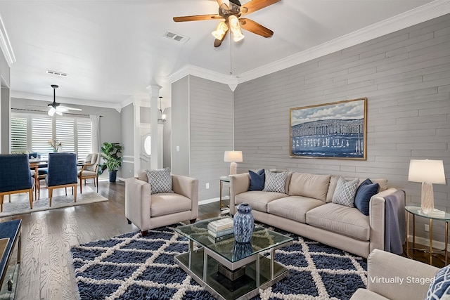 living room with ceiling fan, visible vents, crown molding, and wood finished floors