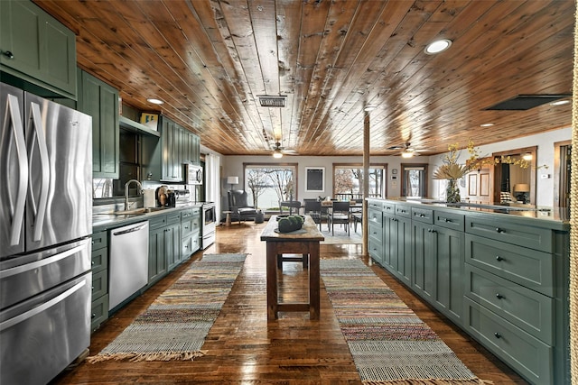 kitchen featuring dark wood finished floors, appliances with stainless steel finishes, a sink, wooden ceiling, and green cabinetry