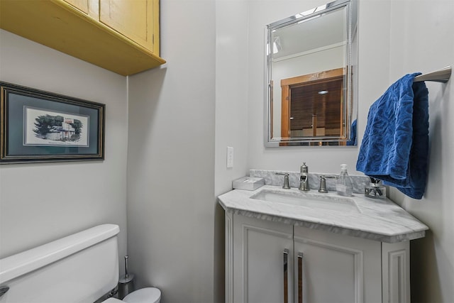 half bathroom featuring vanity and toilet