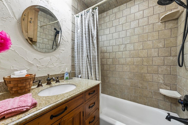 bathroom with a textured wall, vanity, and shower / bath combo with shower curtain