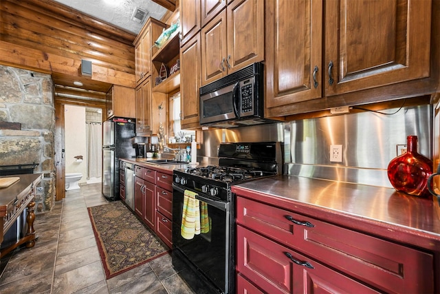 kitchen featuring a textured ceiling, appliances with stainless steel finishes, and a sink