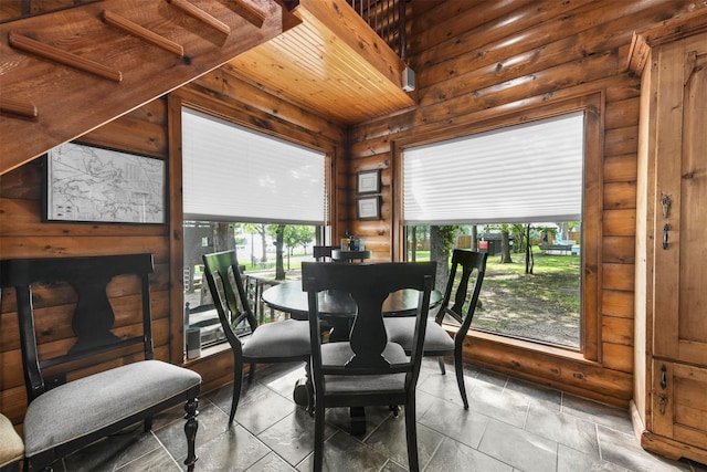 dining room with wooden ceiling and log walls