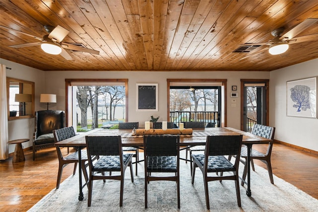 dining area with light wood-type flooring, a healthy amount of sunlight, visible vents, and baseboards