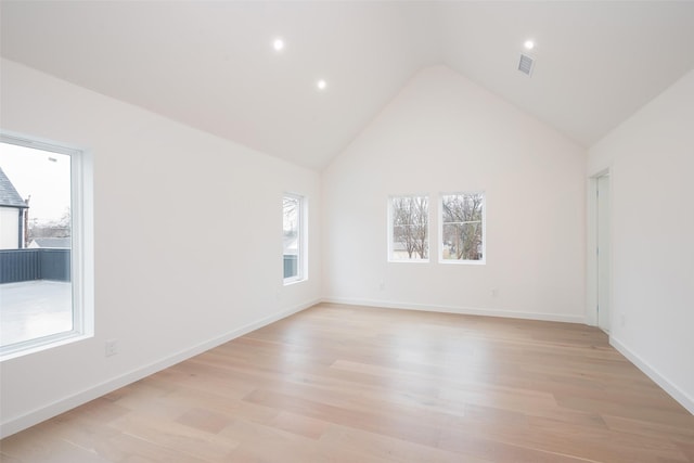 empty room with baseboards, visible vents, high vaulted ceiling, recessed lighting, and light wood-type flooring