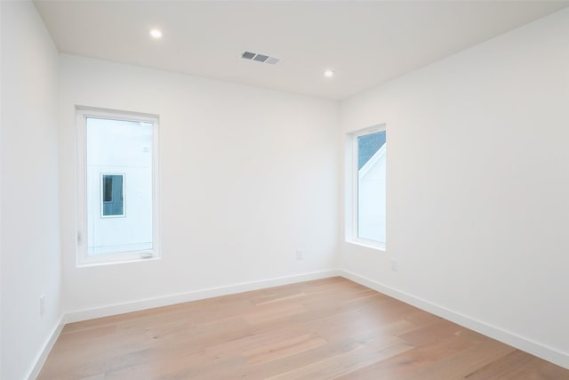 empty room with recessed lighting, visible vents, baseboards, and light wood finished floors