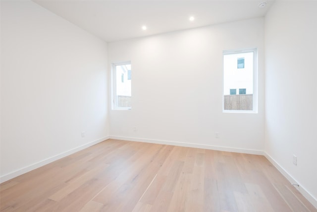 unfurnished room featuring recessed lighting, light wood-type flooring, and baseboards