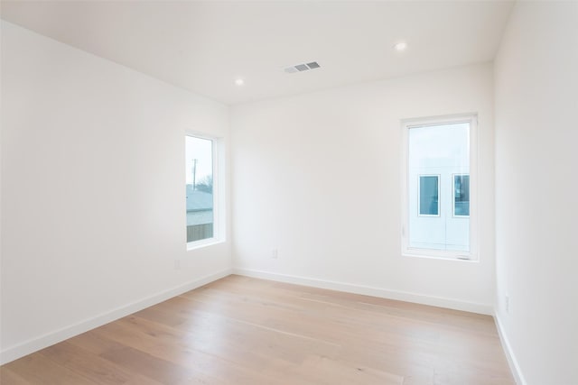 empty room with recessed lighting, baseboards, visible vents, and light wood finished floors