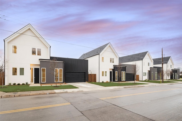 property at dusk featuring an attached garage and driveway