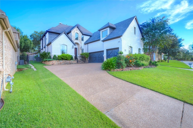 view of front of house with a garage, central AC unit, concrete driveway, fence, and a front yard